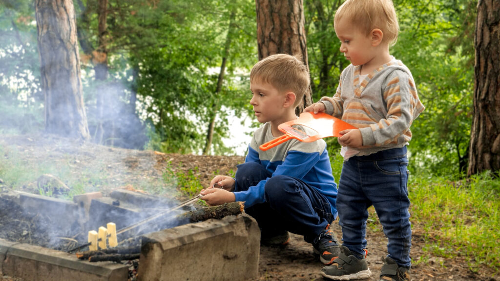 two boys roasting marshmallows at brighter beginnings forest school